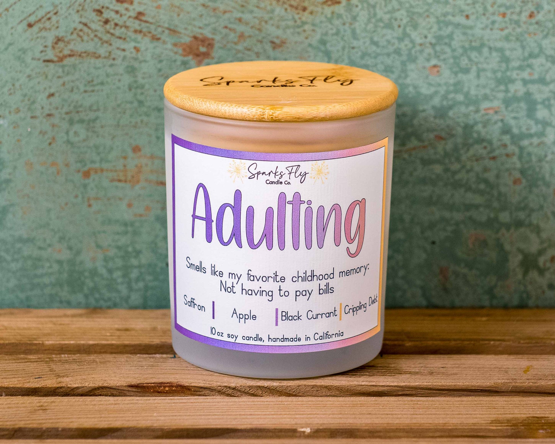 Adulting candle with notes of black currant, absinthe, and apple; capturing childhood memories without bills, satire
